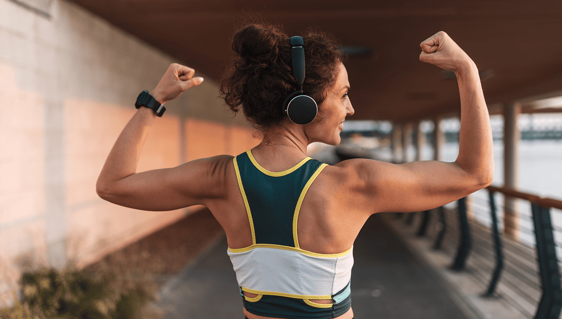 Athlete flexing in sports bra and headphones